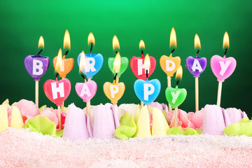 Birthday cake with candles on green background