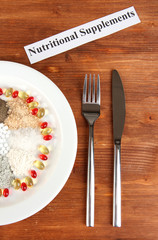 Nutritional supplements on wooden background close-up