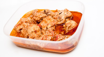 Chicken curry in a lunch box on a white background