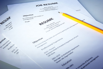 Closeup of resume with pencil on blue background