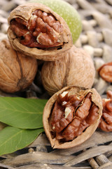 walnuts with green leaves, on  wicker background
