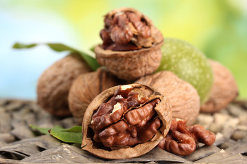 walnuts with green leaves in garden, on green background