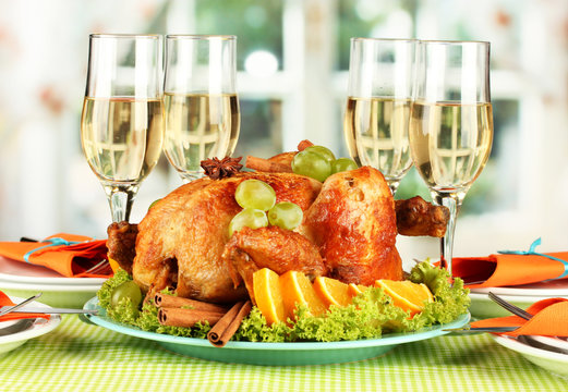 banquet table with roast chicken and glasses of wine.