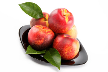 Fototapeta na wymiar Fresh peaches and nectarines on a plate isolated on a white back