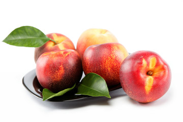 Fresh peaches and nectarines on a plate isolated on a white back