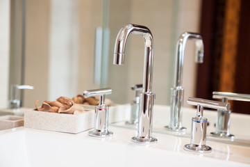 High spout faucet and bowl  in front of a mirror