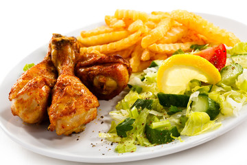 Grilled chicken legs with chips and vegetables