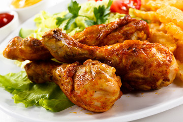 Grilled chicken legs with chips and vegetables