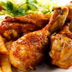 Grilled chicken legs with chips and vegetables