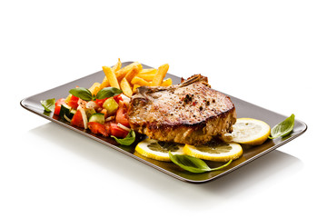 Grilled steaks, French fries and vegetables