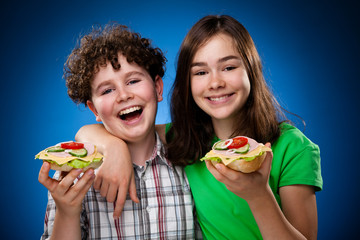 Kids eating big sandwiches