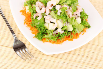 Delicious marinated shrimp in plate on bamboo mat