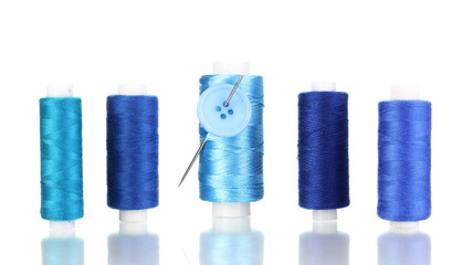 Many blue bobbin with needle and buttons isolated on white
