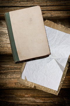 Worn old book and paper on a wooden background