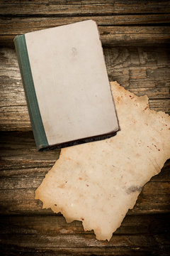 Faded book and aged paper on wood
