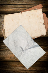 Grungy faded papers on a dark wooden background