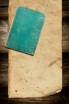 Grungy old book and paper roll on wood