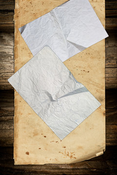 Wrinkled papers on a dark wooden background