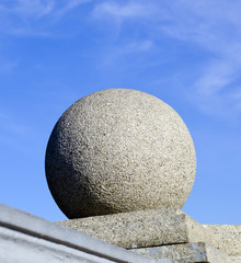 Каменный шар на фоне синего неба
