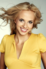 Fototapeta premium Portrait of a blond lady with a beautiful hair isolated on grey