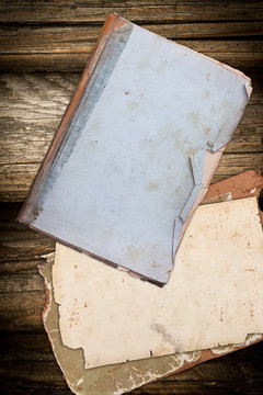Aged book and papers on a wooden background
