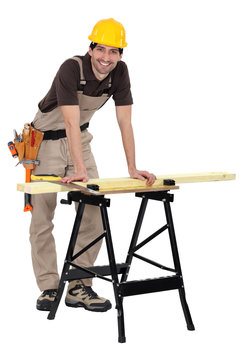 Man sawing wood on workbench