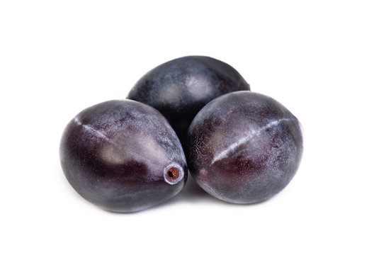 Three fresh blue plums on the white background