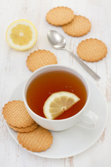 a cup of tea with lemon and cookies