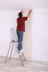 craftsman putting wallpaper