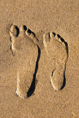 Two footprints in the sand from above