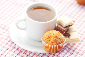 bar of chocolate,tea and muffin on plaid fabric