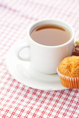 bar of chocolate,tea and muffin on plaid fabric