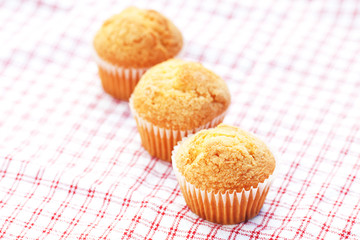 three muffins on plaid fabric