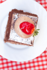 beautiful cake with strawberry on plaid fabric