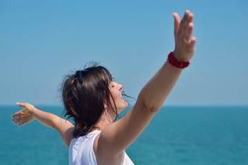 Fototapeta na wymiar happy young woman with spreading arms to sky