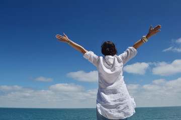 happy young woman with spreading arms to sky