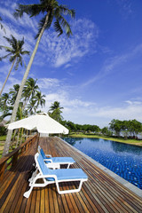 Chair on swimming pool beside the beach