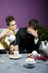 The girl pours milk in coffee of the man