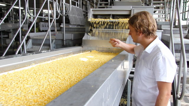 Worker controls processing of corn