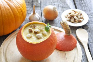 Pumpkin soup and components on old wooden table