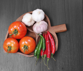 Tomatoes, garlic, and pepper in wooden bowl