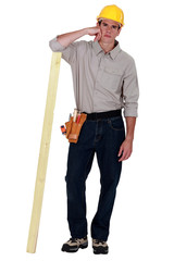 full length shot of carpenter with arm resting on plank