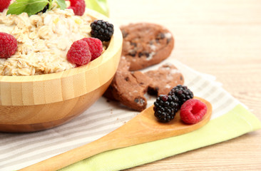 tasty oatmeal with berries, on wooden table