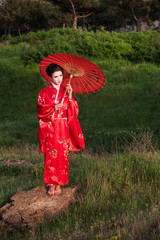 Geisha in the green hills at the sunset