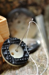 Nadel und Naturgarn mit Knopf