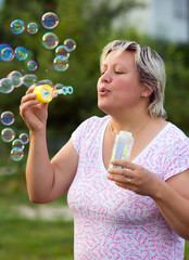 Woman blowing bubbles outdoors