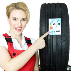 Female car mechanic showcases tire label
