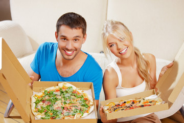 romantic couple eating pizza at home