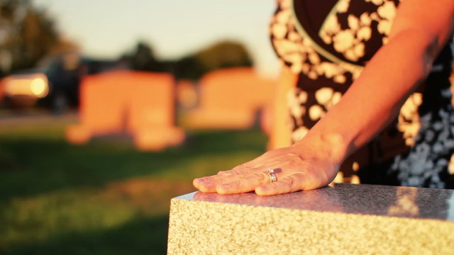 Woman Visits Grave in Cemetery