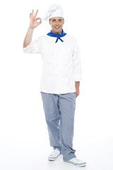 Full length portrait of chef showing okay sign